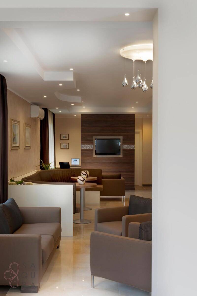 Stilvoller Loungebereich mit bequemen Sofas, einem Fernseher und indirekter Beleuchtung.