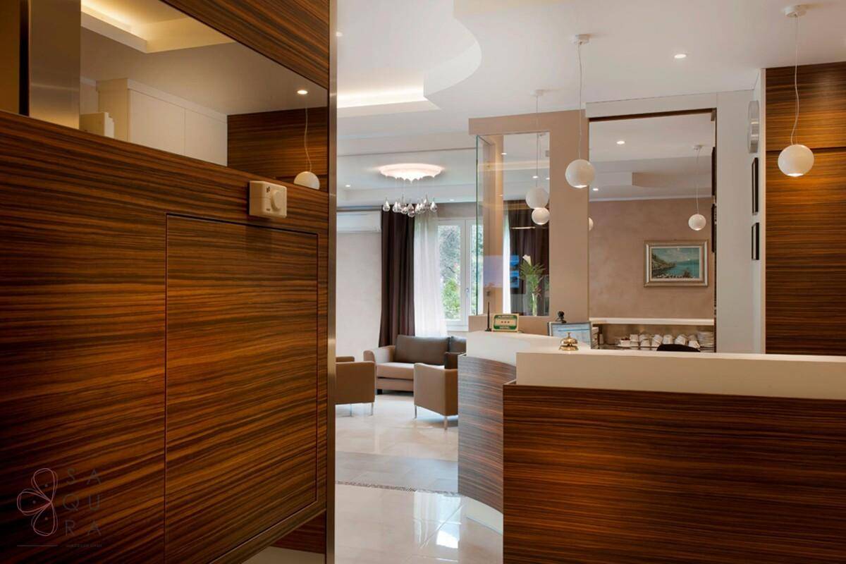Moderne Rezeption mit eleganten Holzvertäfelungen und einem Blick in den angrenzenden Loungebereich.