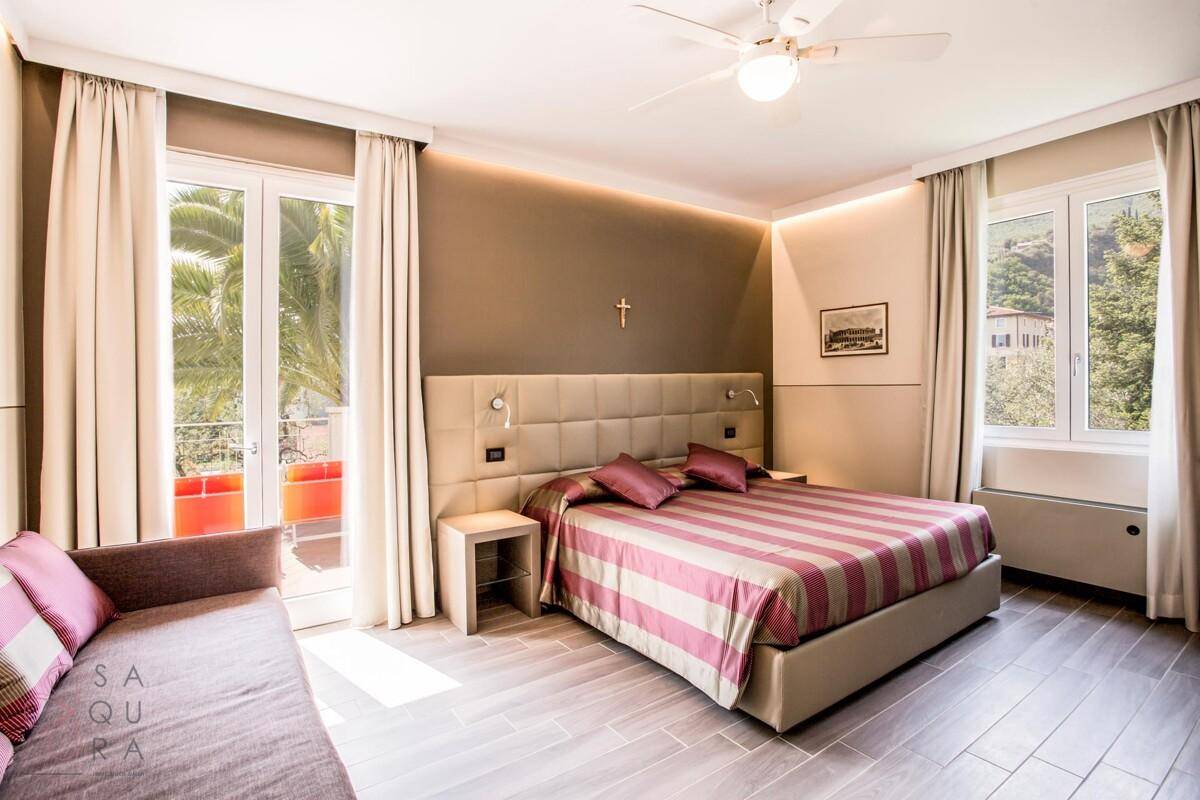 Modernes Schlafzimmer mit großem Bett, indirekter Beleuchtung und Zugang zu einem Balkon.