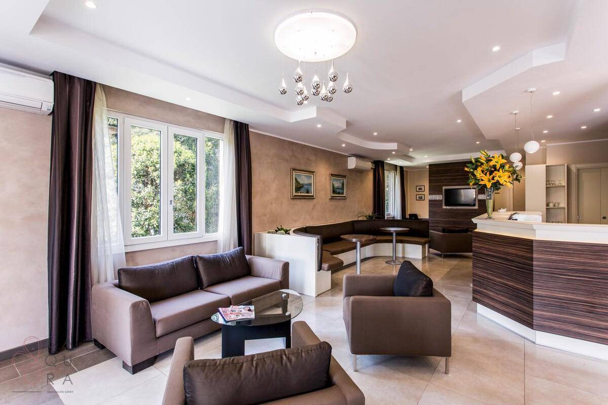 Geräumiger Loungebereich mit großen Fenstern, bequemen Sitzgelegenheiten und moderner Einrichtung.