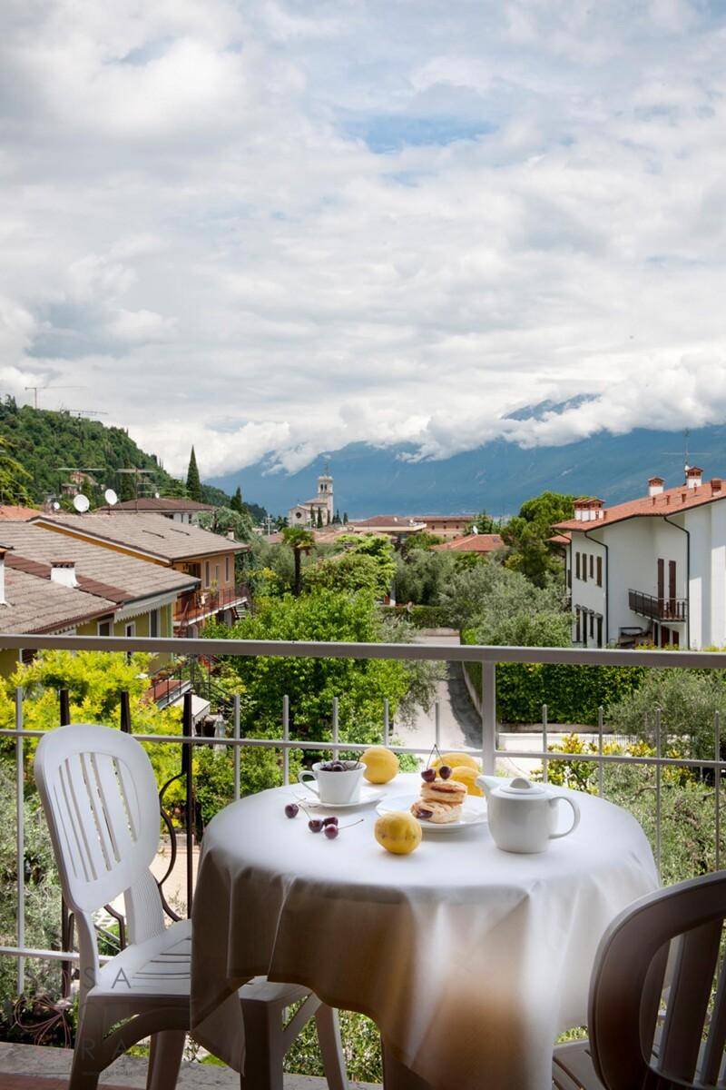 Balkon mit einem gedeckten Tisch für Frühstück und einem weiten Blick auf die Berglandschaft.