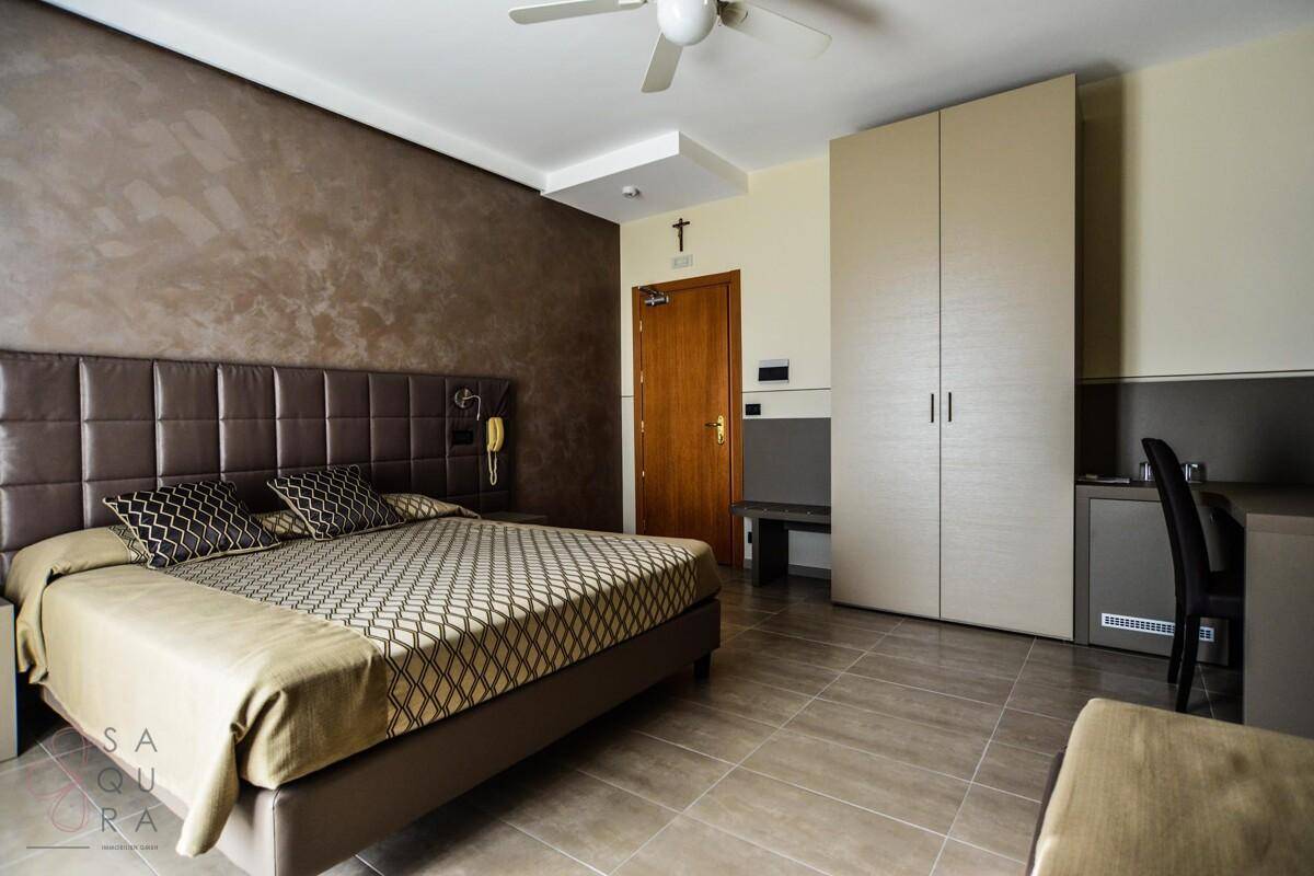 Geräumiges Schlafzimmer mit großem Bett, Deckenventilator und einem integrierten Kleiderschrank.