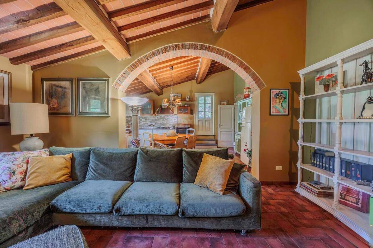 Offener Wohnbereich mit gemütlichem Sofa und Blick auf die angrenzende Küche.