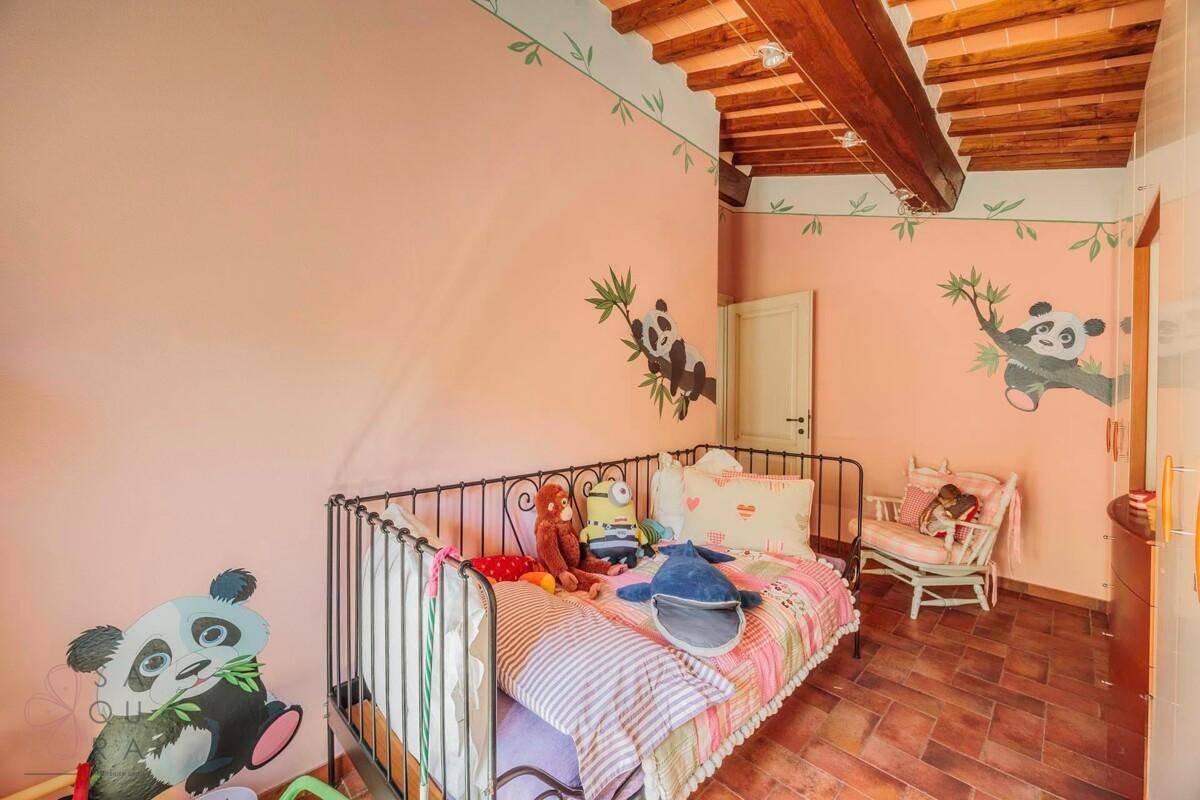Farbenfrohes Kinderzimmer mit Einzelbett, Panda-Wanddekoration und Holzbalkendecke.