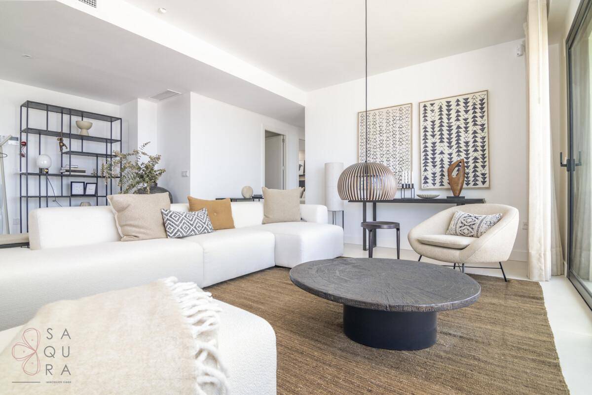 Helles Wohnzimmer mit großem weißen Sofa, modernem Couchtisch und stilvoller Dekoration.