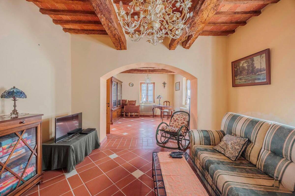 Geräumiger Wohnbereich mit gestreiftem Sofa, Fernseher und Blick in den Essbereich.