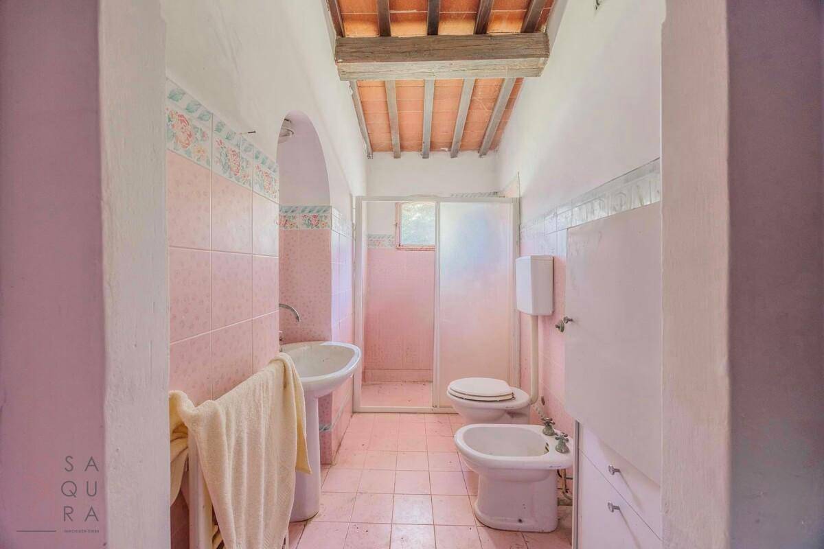 Rosa gefliestes Badezimmer mit Dusche, Bidet und traditionellen Armaturen.