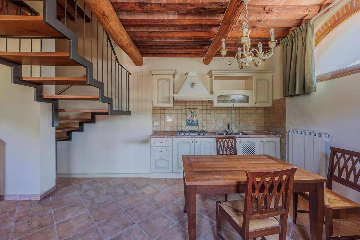 Offene Küche mit Esstisch, traditionellen Schränken und moderner Treppe zu den oberen Etagen.