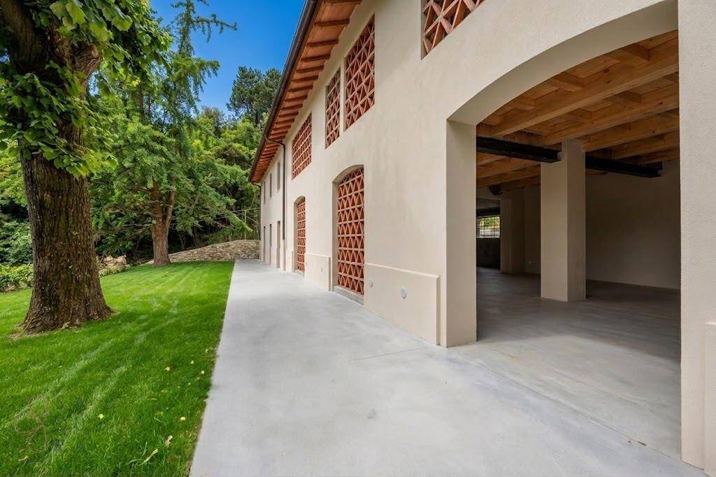 Seitenfassade des Hauses mit großen Bögen und Blick auf den noch unfertigen Innenbereich.