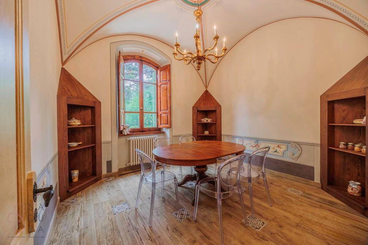 Elegantes Esszimmer mit gewölbter Decke, Holzboden und einem ovalen Esstisch mit modernen Stühlen.