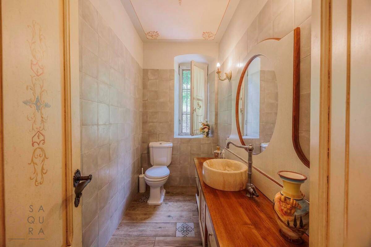 Modernisiertes Gäste-WC mit Holzwaschtisch, Aufsatzwaschbecken und einem Fenster für Tageslicht.
