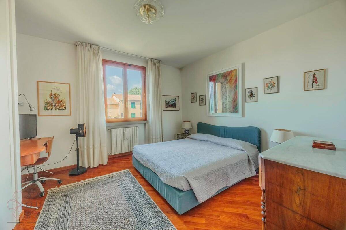 Komfortables Schlafzimmer mit Holzboden, blauem Bett und Blick ins Grüne.