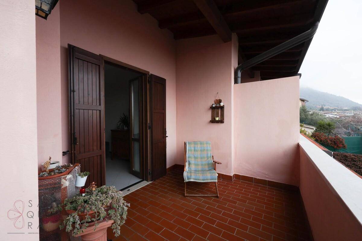 Gemütlicher Balkon mit Terrakottafliesen, einem Stuhl und Pflanzen, ideal zum Entspannen.