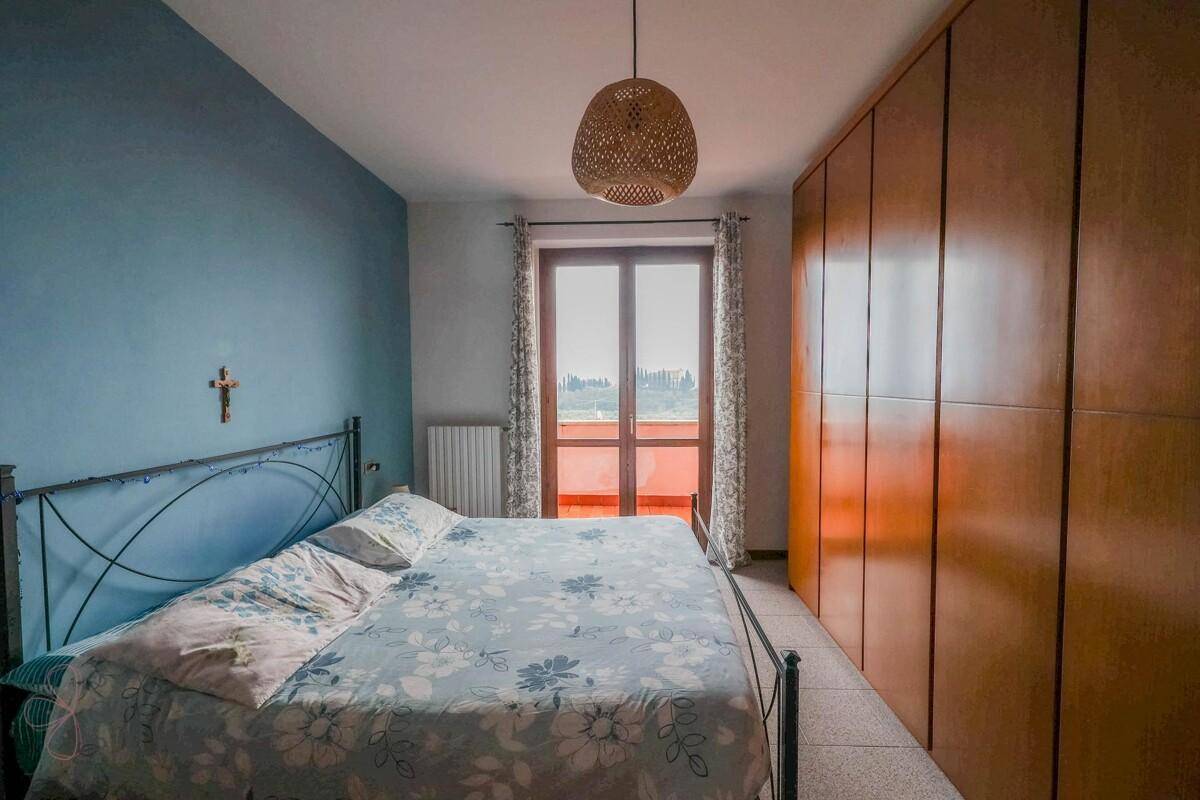 Schlafzimmer mit blauer Akzentwand, Doppelbett und großem Kleiderschrank, hell und freundlich.