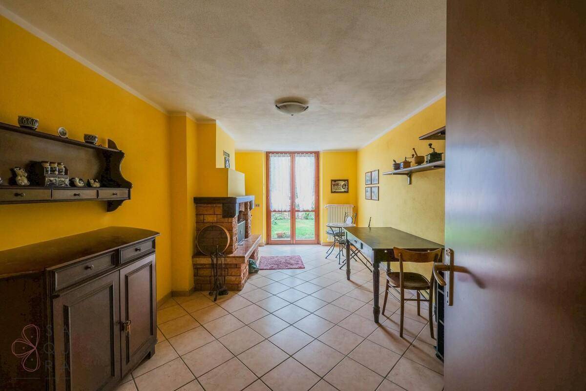 Gemütliches Zimmer mit gelben Wänden, einem Kamin und direktem Zugang zum Garten.