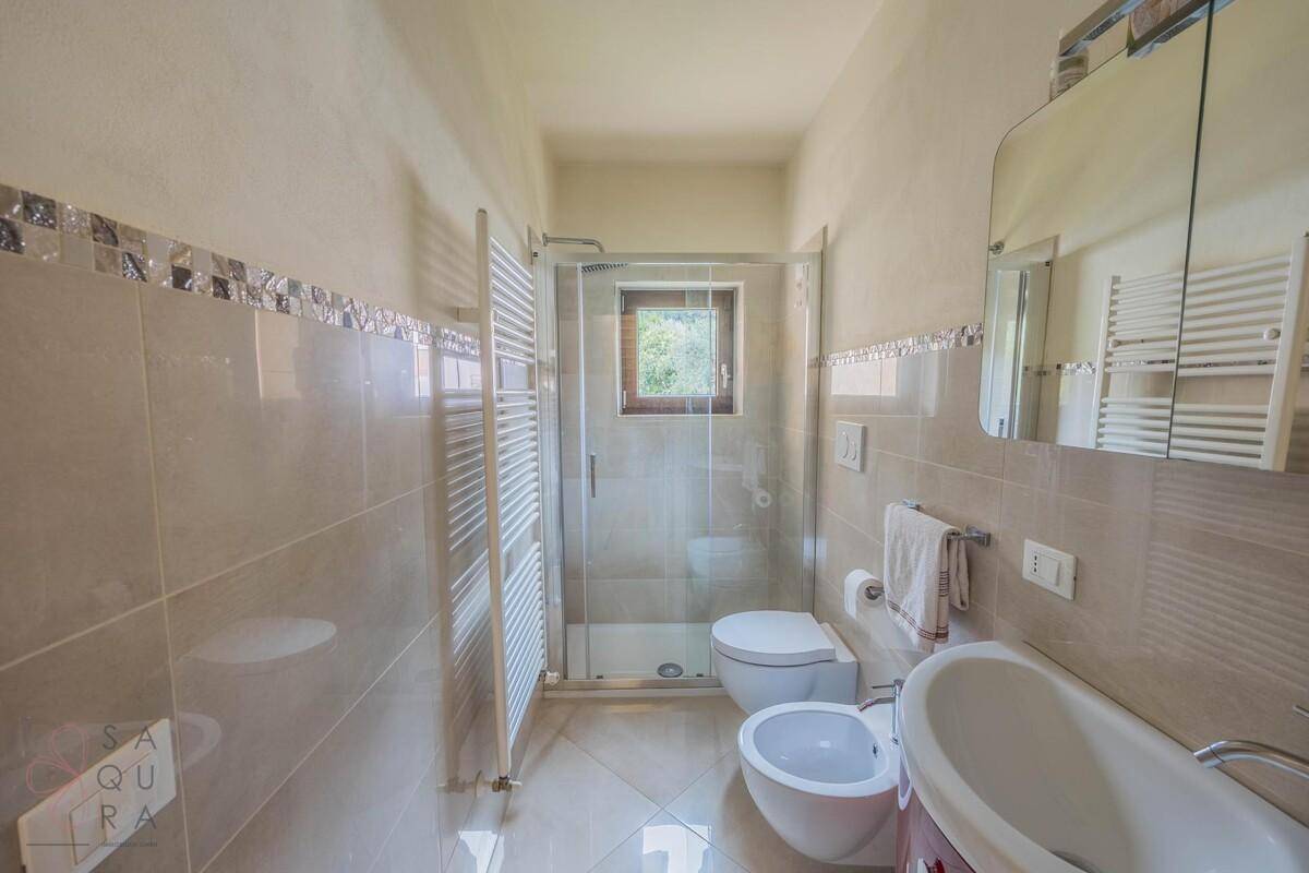 Modernes Badezimmer mit Dusche, Bidet, WC und beheiztem Handtuchhalter.