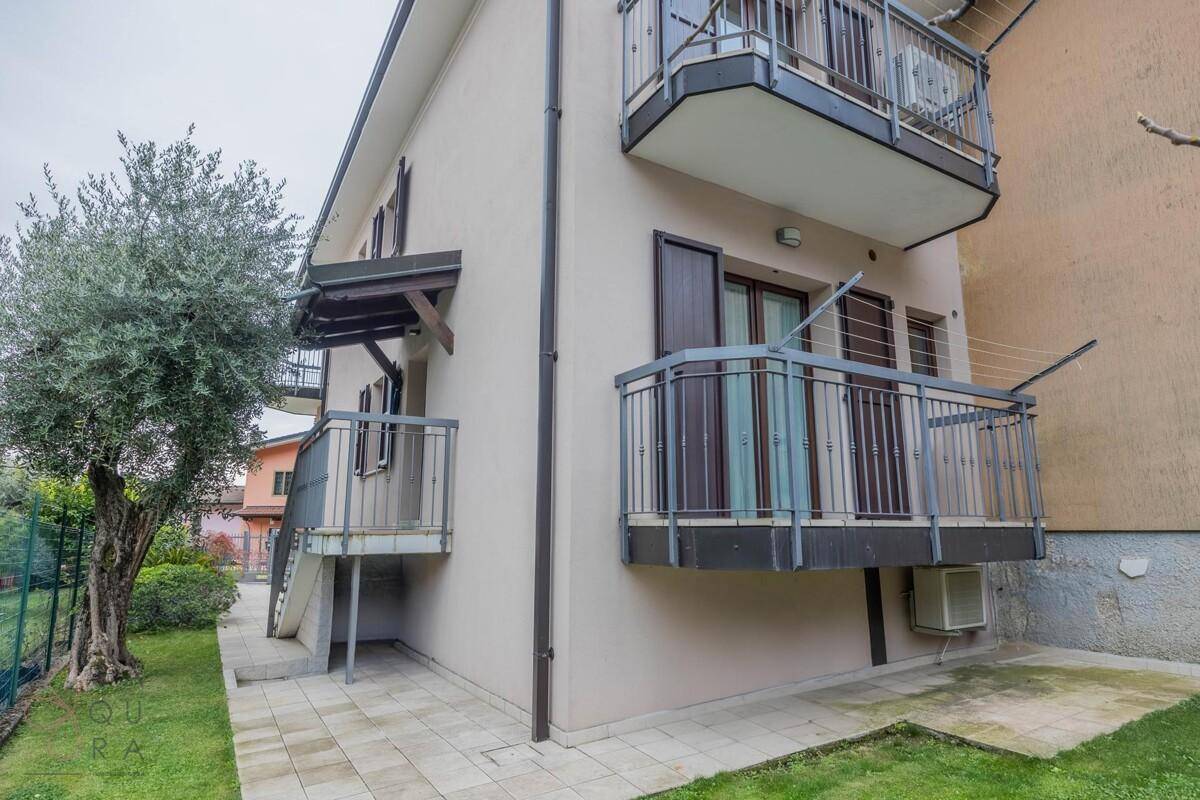 Rückseite des Hauses mit mehreren Balkonen und Zugang zum Gartenbereich.