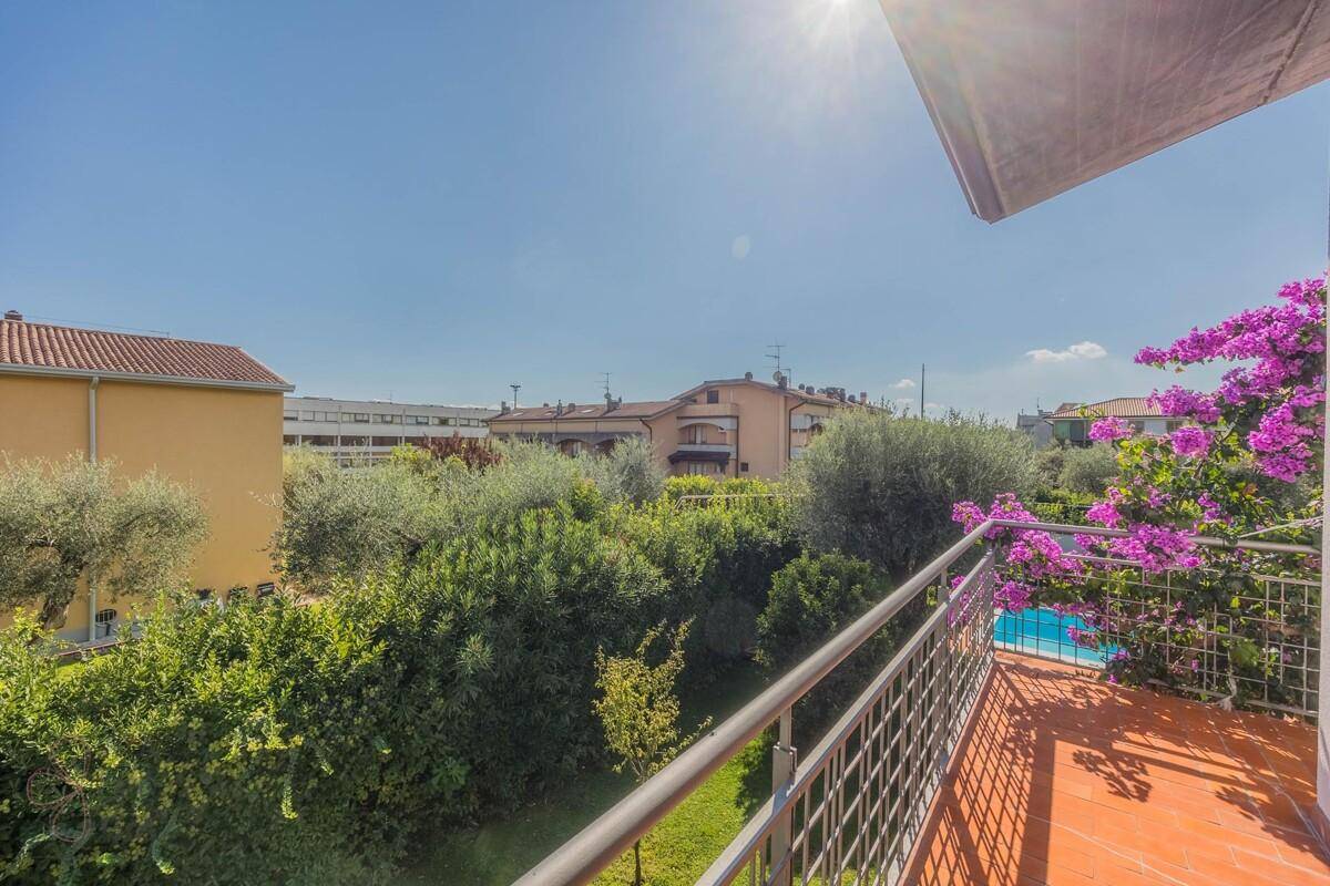 Balkon mit weitem Blick über die grüne Umgebung und die Dächer der Nachbarschaft.