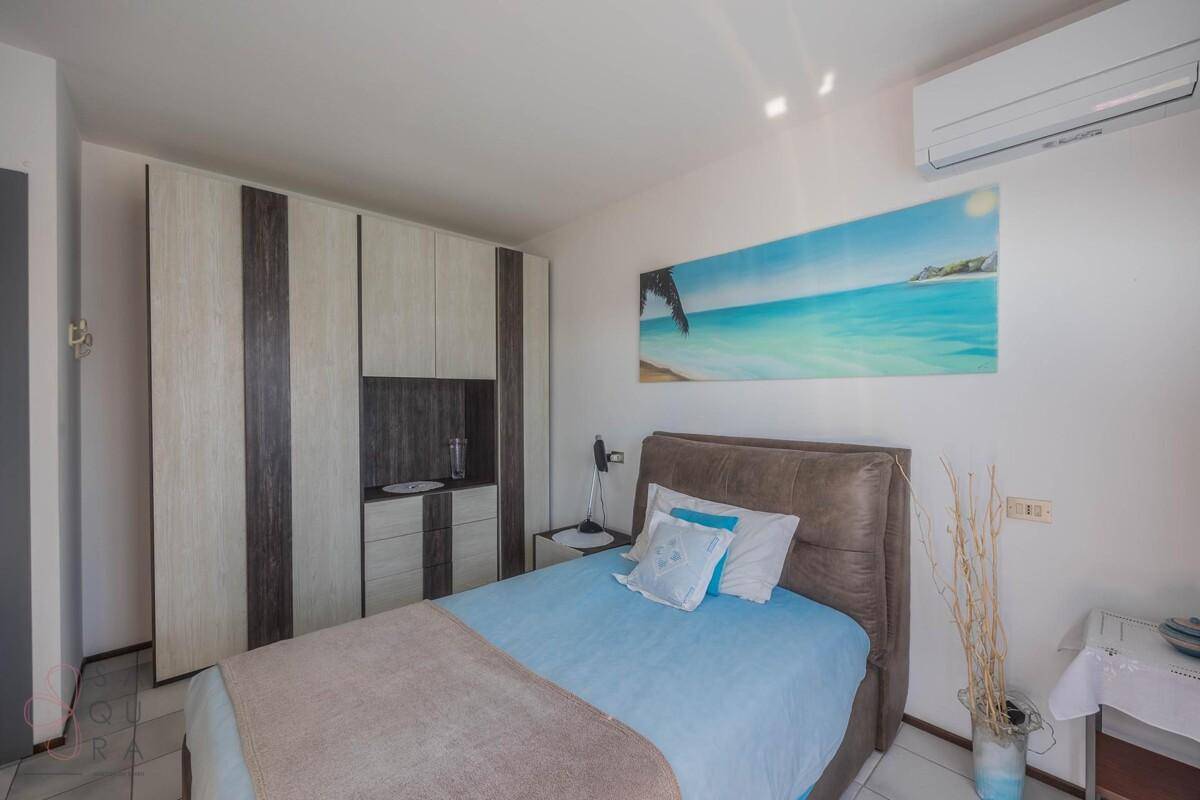 Schlafzimmer mit großem Einbauschrank, Einzelbett und Klimaanlage.