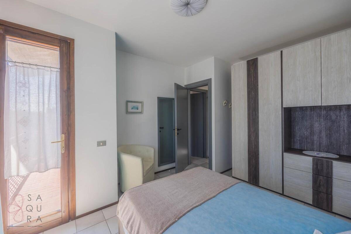 Schlafzimmer mit Zugang zu einem Balkon und großem Einbauschrank.