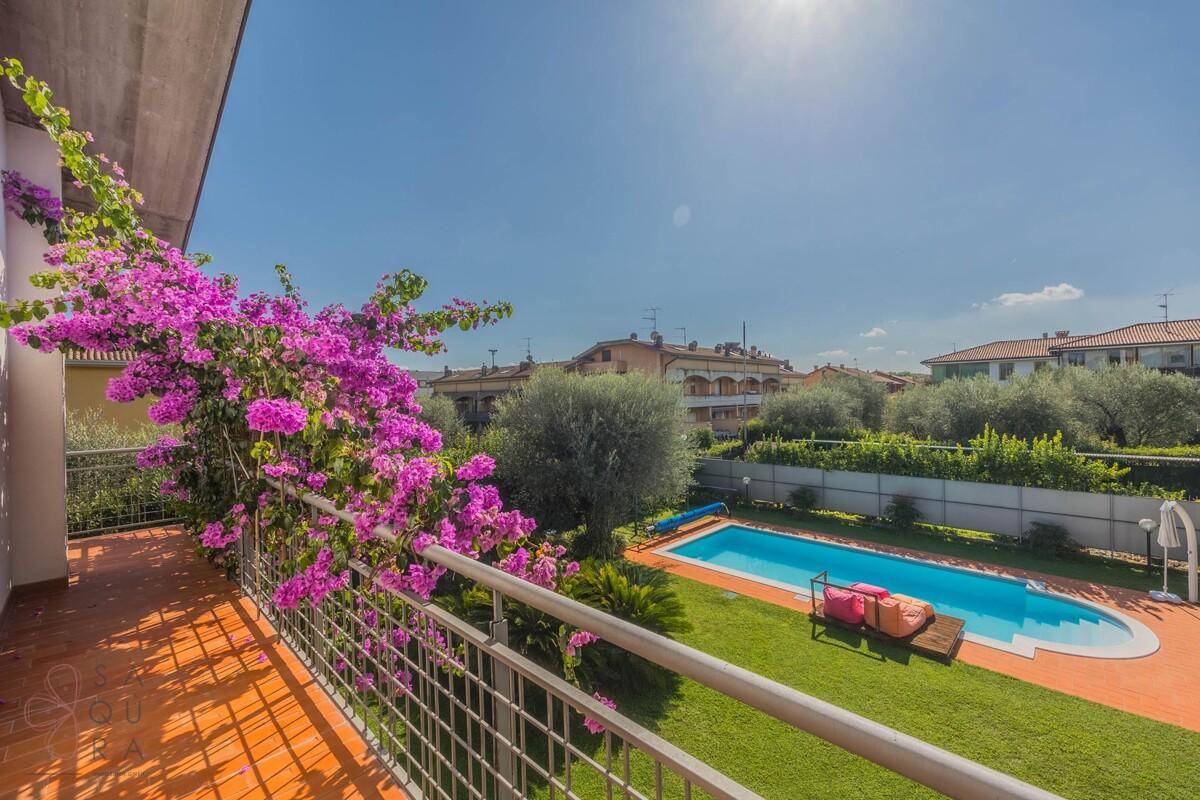 Geräumiger Balkon mit Blick auf den Pool, den Garten und die umliegende Landschaft.
