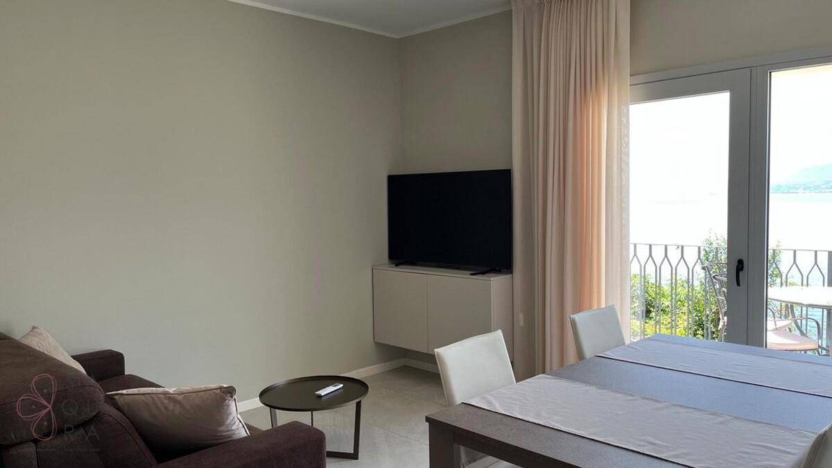 Komfortabler Wohnbereich mit Sofa, Fernseher und Essbereich, hell und modern gestaltet.
