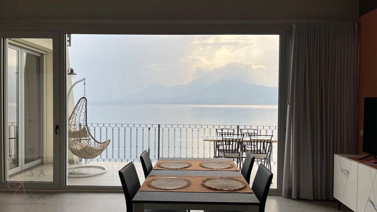 Heller Essbereich mit großem Fenster und atemberaubendem Blick auf den See und die Berge.