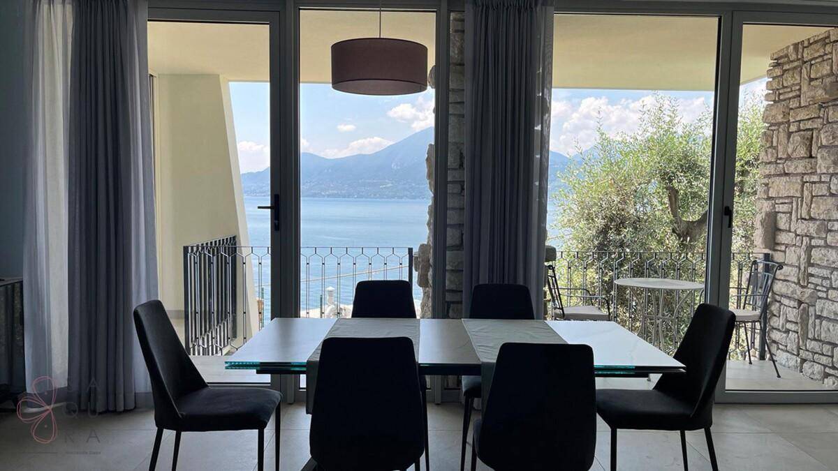 Heller Essbereich mit großem Esstisch und weitem Blick über den See und die Berge.