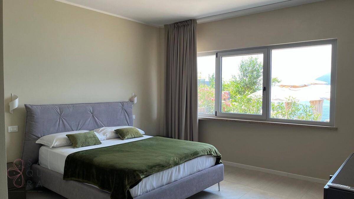 Komfortables Schlafzimmer mit Doppelbett und Blick ins Grüne, modern eingerichtet.