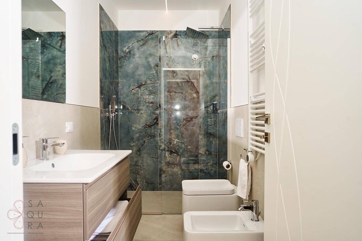 Modernes Badezimmer mit begehbarer Dusche, Bidet und beheiztem Handtuchhalter.