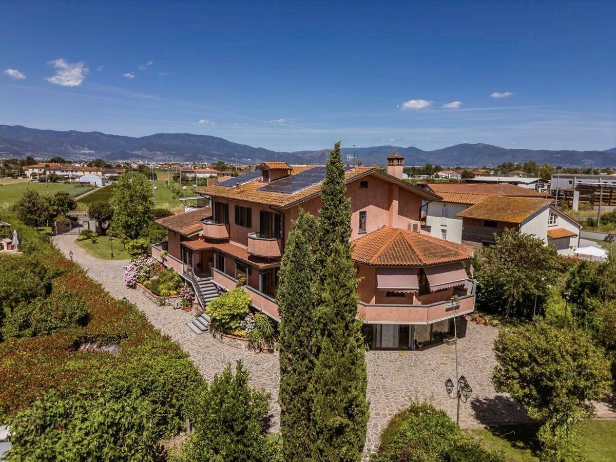 Luftaufnahme des Anwesens mit großem Garten, Pool und umliegender Landschaft.