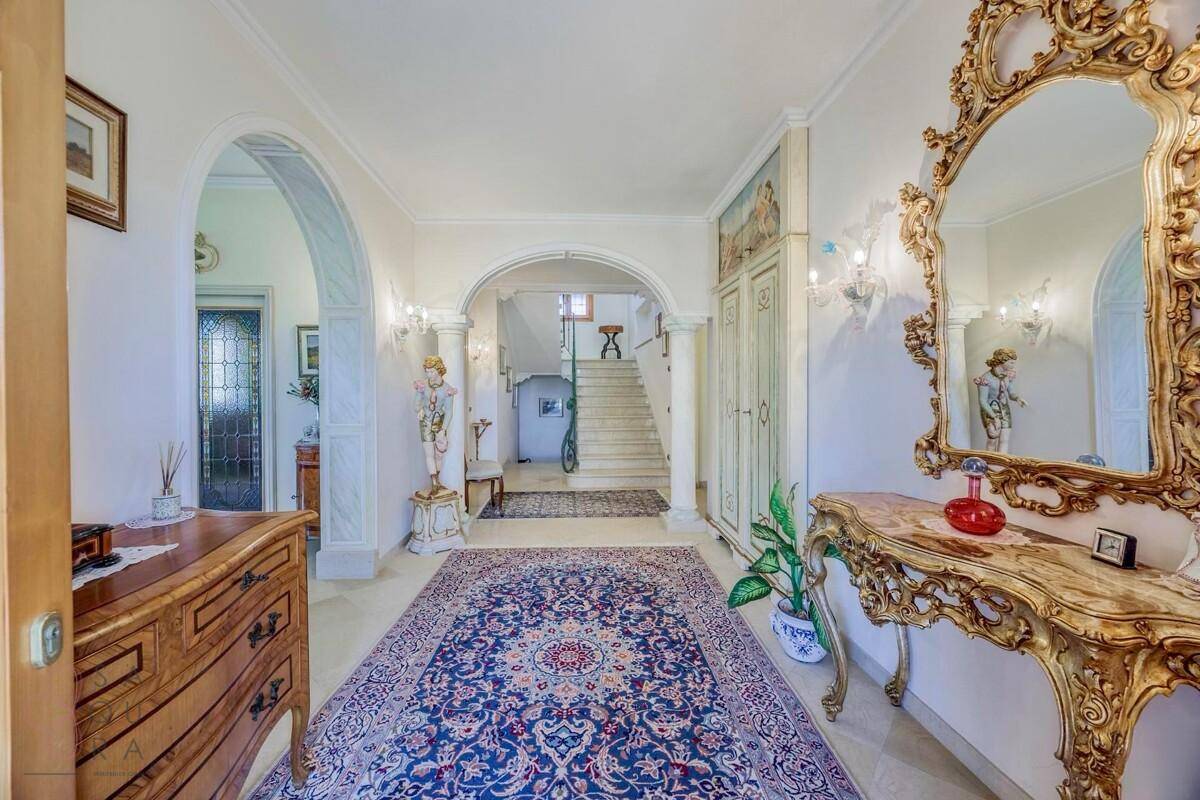 Eleganter Eingangsbereich mit Marmorboden, opulentem Spiegel und klassischer Einrichtung.
