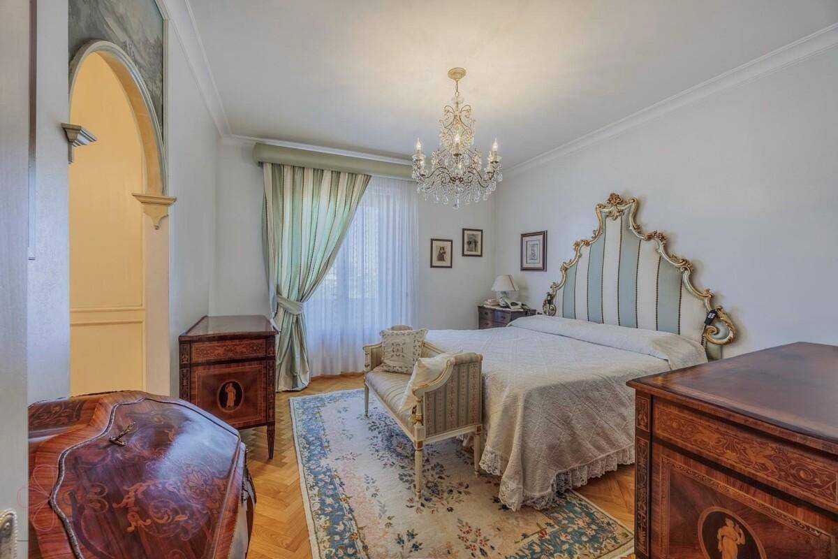 Stilvolles Schlafzimmer mit Doppelbett, Parkettboden und antiken Möbeln.