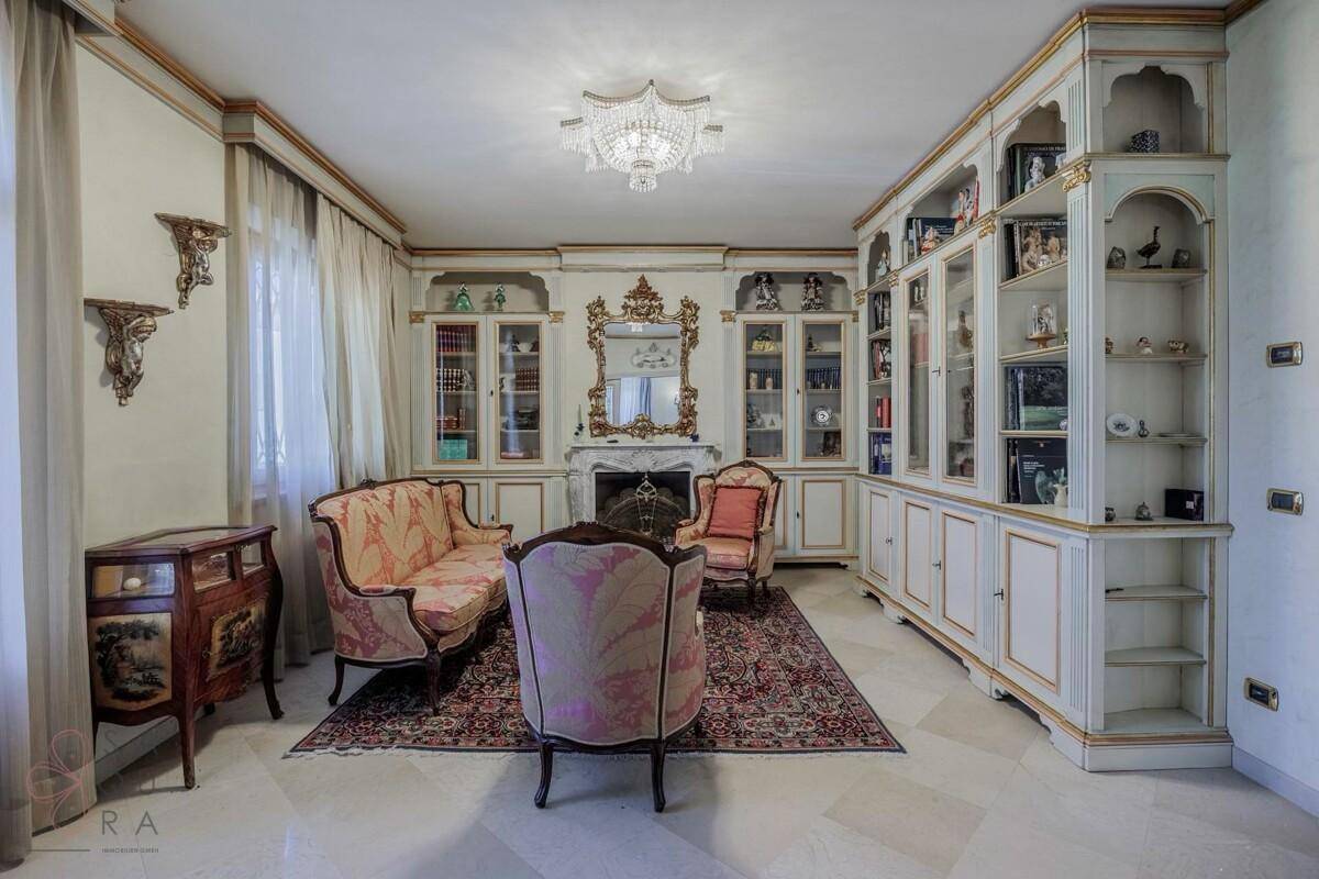 Elegantes Wohnzimmer mit integrierten Bücherregalen, Kamin und klassischem Mobiliar.