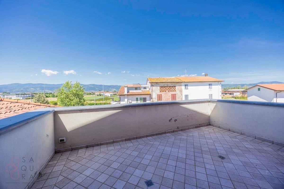 Geräumige Dachterrasse mit Fliesenboden und weitem Blick über die Umgebung.