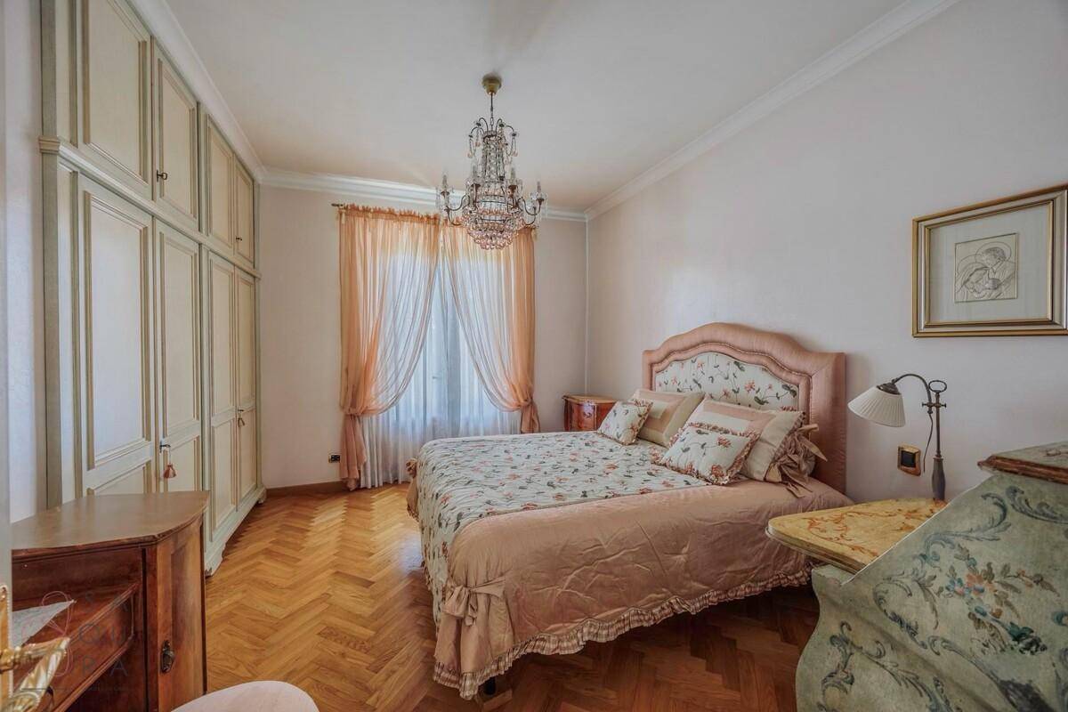 Gemütliches Schlafzimmer mit Doppelbett, Parkettboden und eleganten Einbauschränken.