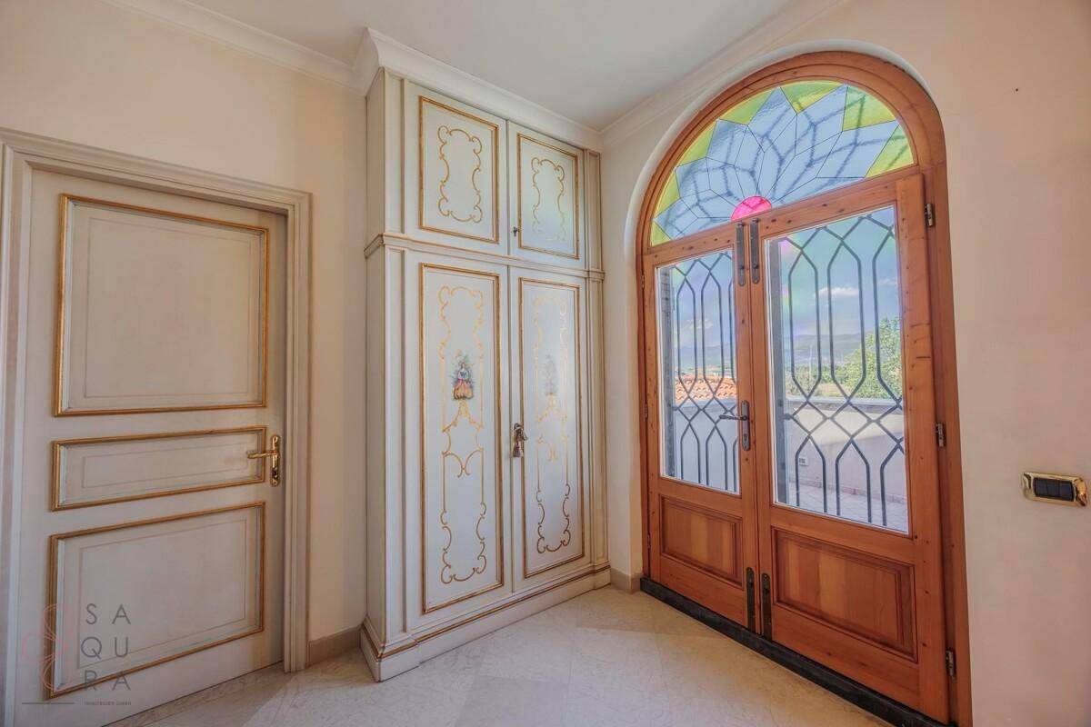 Heller Flur mit dekorativer Holztür, Buntglasfenster und elegantem Einbauschrank.