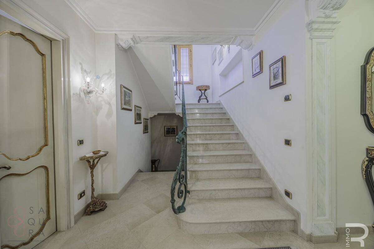 Repräsentatives Treppenhaus mit Marmorstufen, schmiedeeisernem Geländer und eleganten Details.
