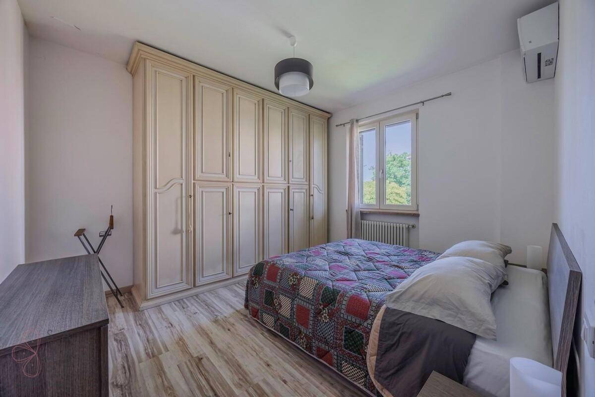Schlafzimmer mit großem Kleiderschrank, Doppelbett und Laminatboden.