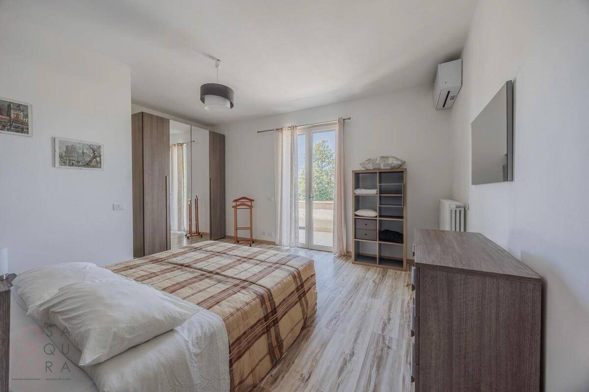 Geräumiges Schlafzimmer mit Doppelbett, Schrank und direktem Zugang zum Balkon.