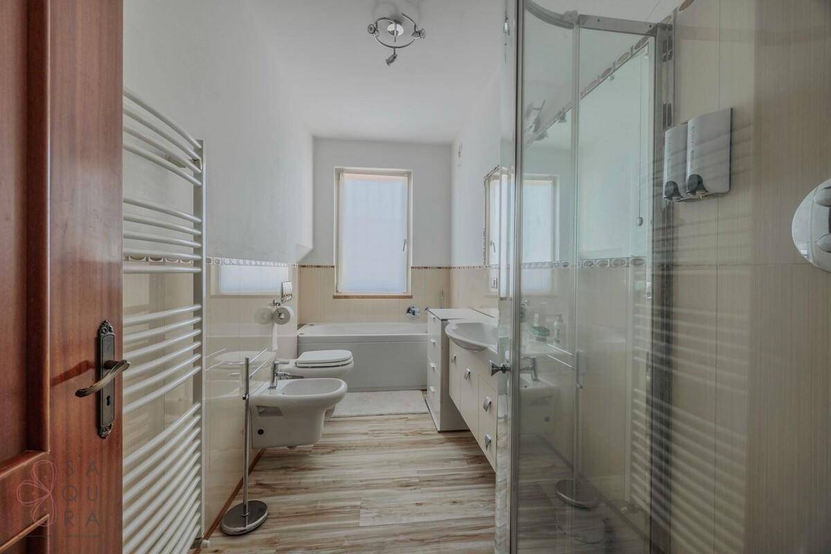 Modernes Badezimmer mit Dusche, Badewanne, Bidet und beheiztem Handtuchhalter.