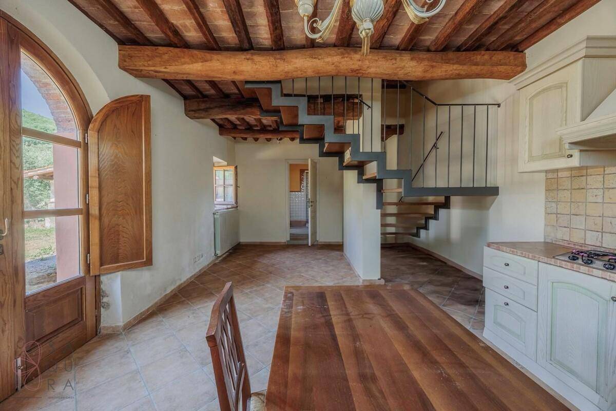 Helle Küche mit Essbereich und offener Treppe, die den Raum strukturiert.