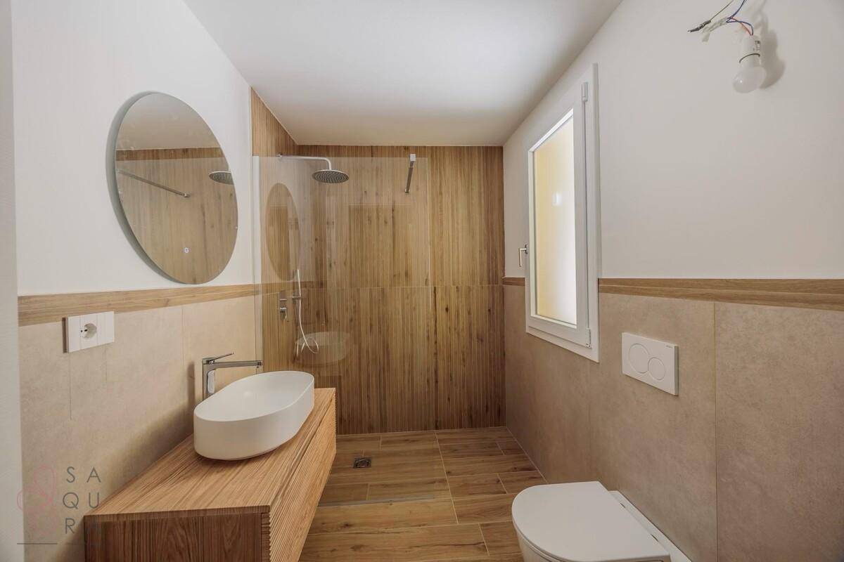 Modernes Badezimmer mit Holzakzenten, begehbarer Dusche und ovalem Aufsatzwaschbecken.