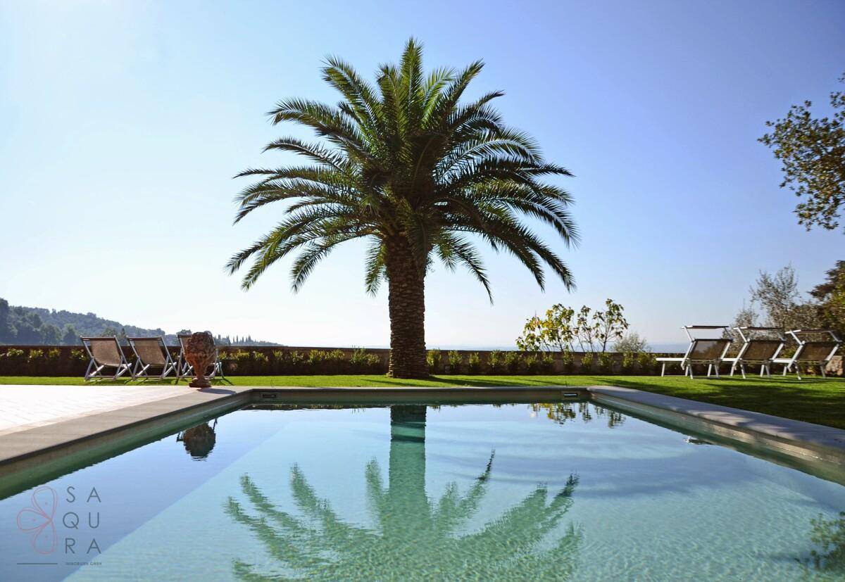 Infinity-Pool mit atemberaubendem Fernblick über die Landschaft und Palmen im Garten.