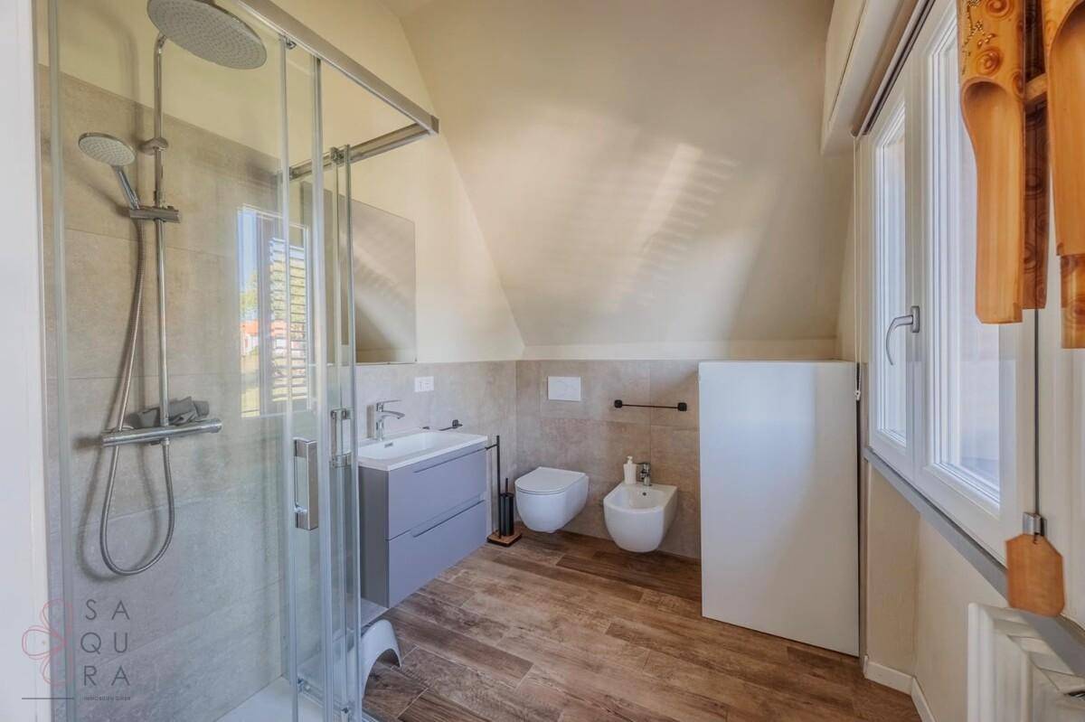 Modernes Badezimmer mit begehbarer Dusche, Bidet und Dachschräge.