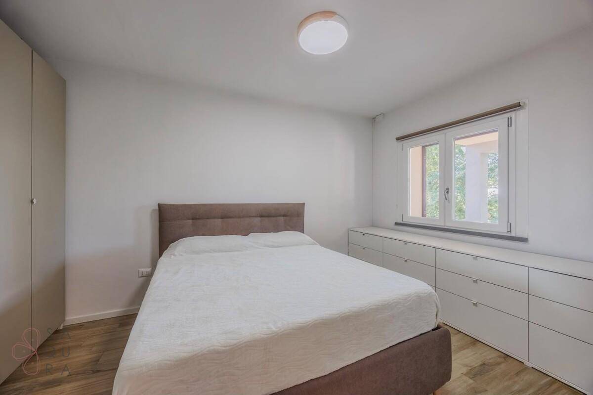Modernes Schlafzimmer mit Holzboden, großem Bett und integrierten Kommoden.