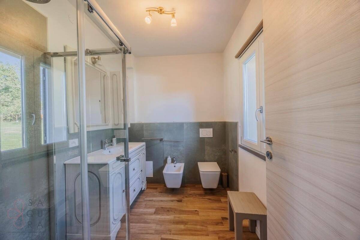 Helles Badezimmer mit Dusche, Bidet und Fenster für natürliche Belüftung.