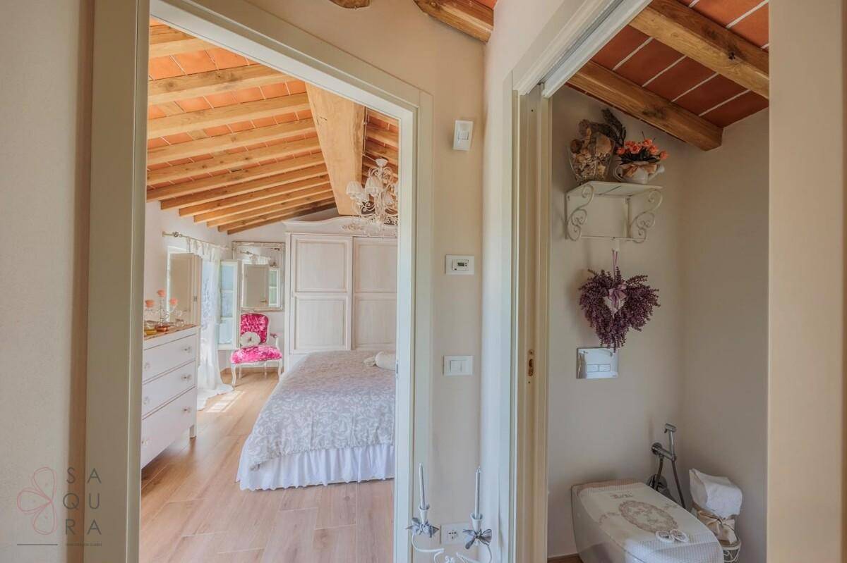 Flur mit Blick in ein Schlafzimmer und Zugang zu einer separaten Toilette.