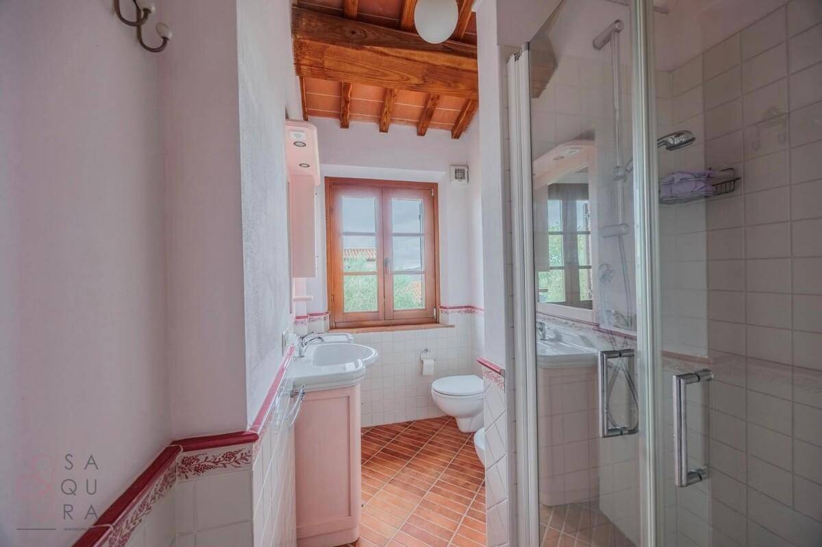 Badezimmer mit Dusche, Terrakottaboden und traditionellen Fliesenakzenten.