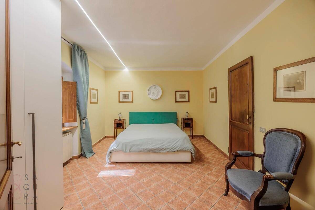Helles Schlafzimmer mit gelben Wänden, Terrakottaboden und modernem Bett.